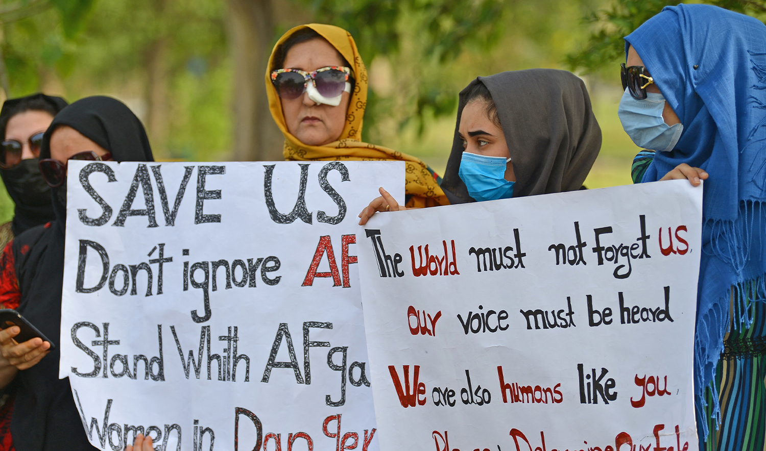 Afghans hold placards as they gather to demand help from the United Nations High Commissioner for Refugees (UNHCR) for asylum abroad, in Islamabad on May 12, 2022. (AFP)