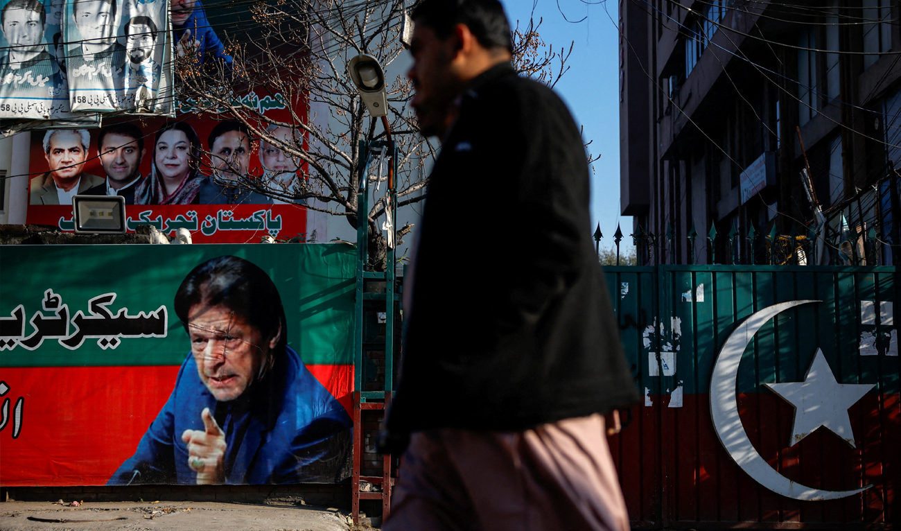 People walk past a banner with a picture of the former Prime Minister Imran Khan outside the party office of Pakistan Tehreek-e-Insaf (PTI), in Lahore, Pakistan on February 9, 2024. (REUTERS/File)