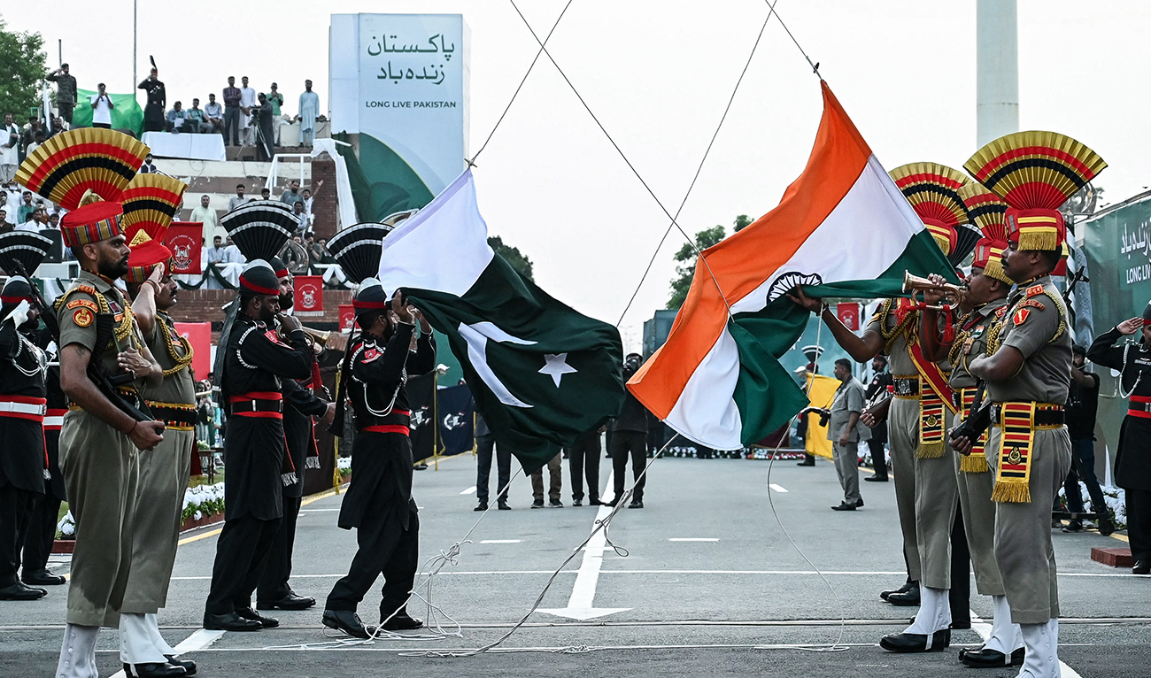 In this file photo, taken on August 14, 2024, Indian Border Security Force personnel (brown uniform) and Pakistani Rangers (black uniform) take part in the beating retreat ceremony, on the occasion of Pakistan’s Independence Day and eve of India’s Independence Day at the India-Pakistan Wagah border post. (AFP/File)