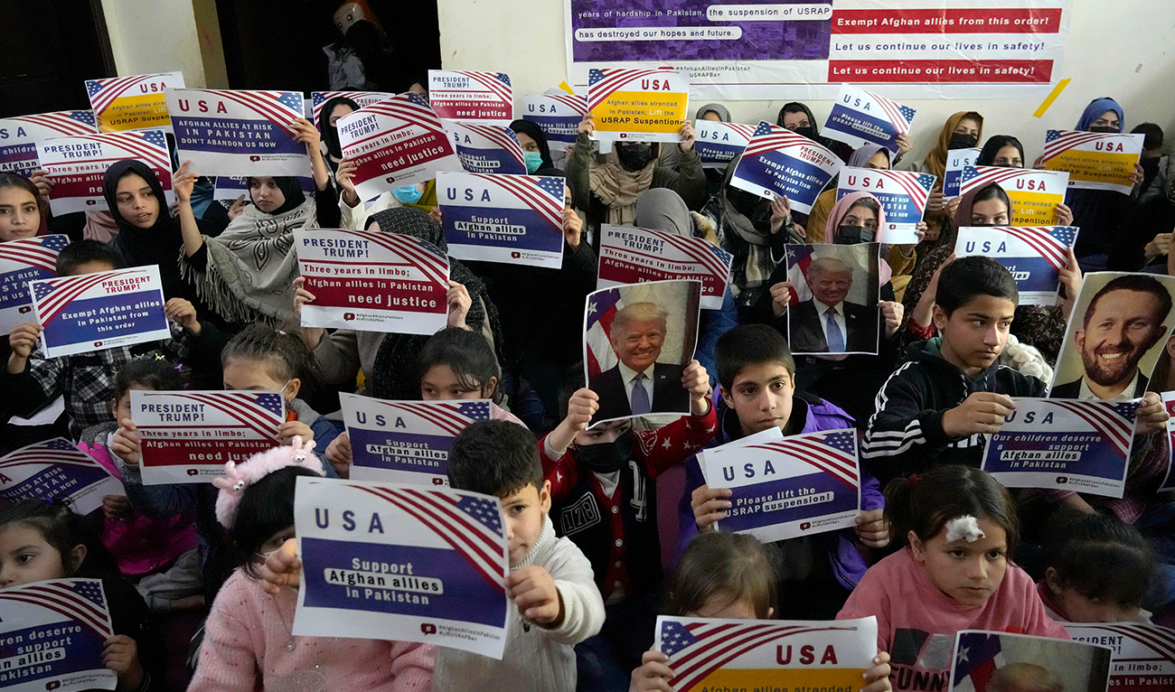 Afghan refugees hold placards during their meeting to discuss situation after President Donald Trump paused the US refugee programs, in Islamabad on January 24, 2025. (AP)
