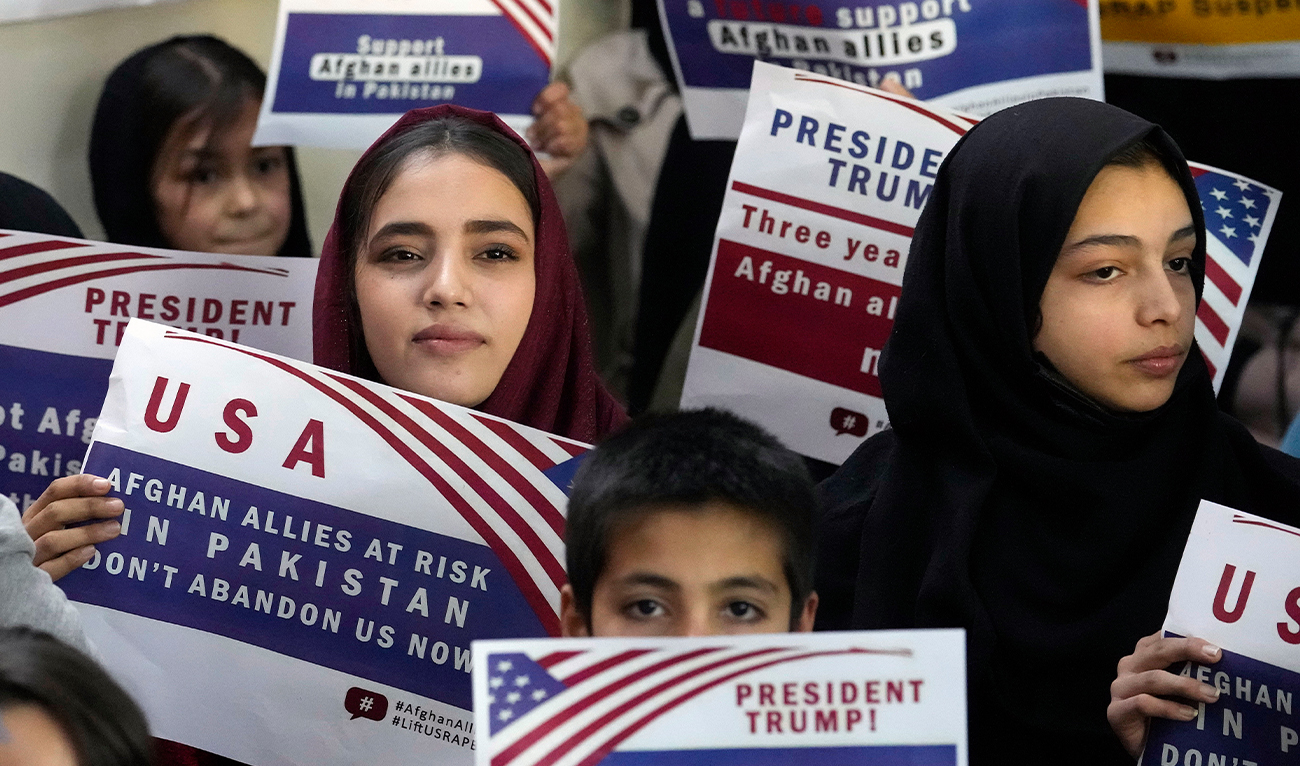 Afghan refugees hold placards during a meeting to discuss their situation after President Donald Trump paused US refugee programs, in Islamabad, Pakistan, on January 24, 2025. (AP)