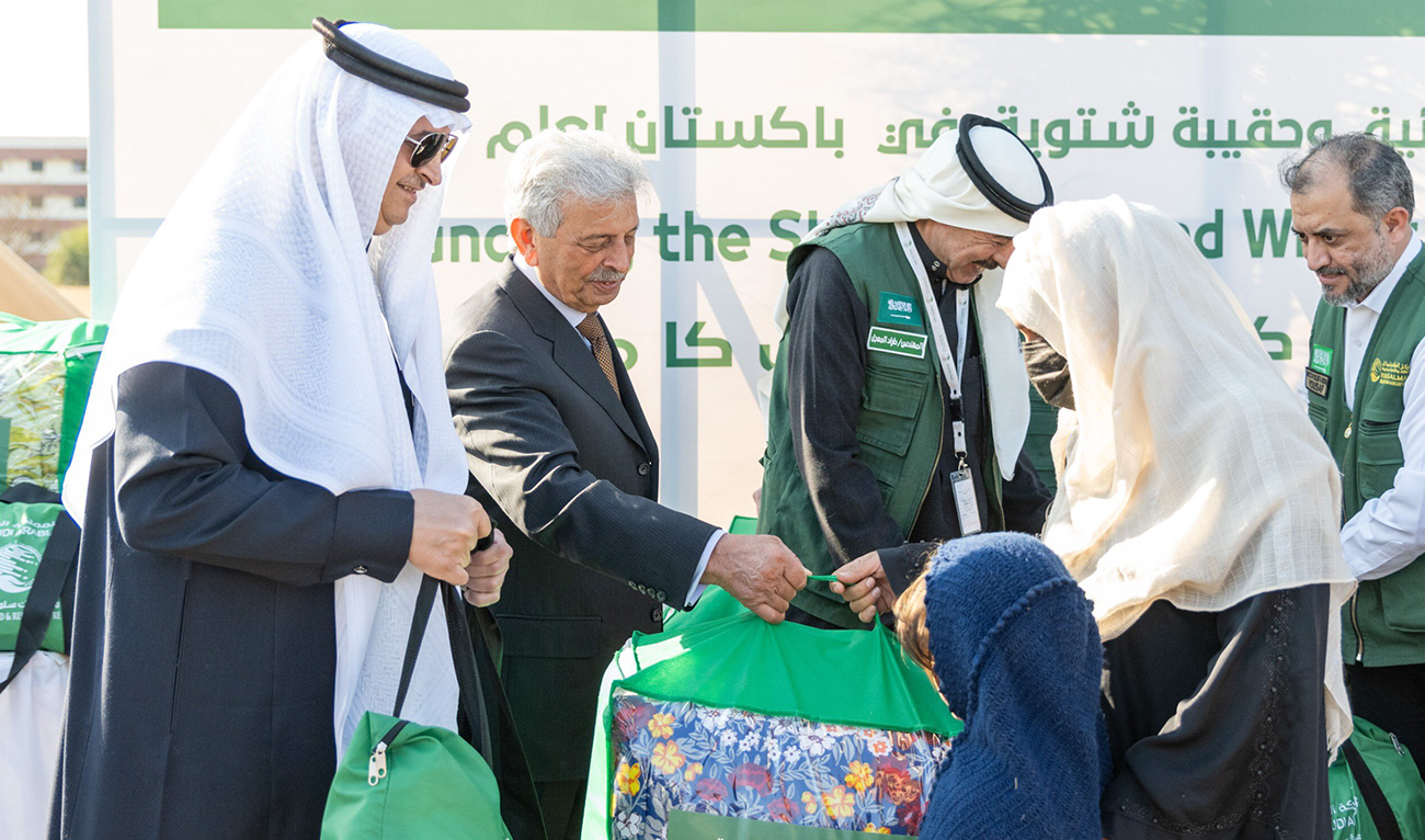 In this handout photo, released by Saudi Embassy, Pakistan’s National Food Security Minister Rana Tanveer Hussain (2L) and Saudi Ambassador Nawaf bin Said Al-Malki handover packages during the launching ceremony of KSrelief’s 2025 winter kits project in Islamabad on January 30, 2025. (Photo courtesy: X/@KSAembassyPK)