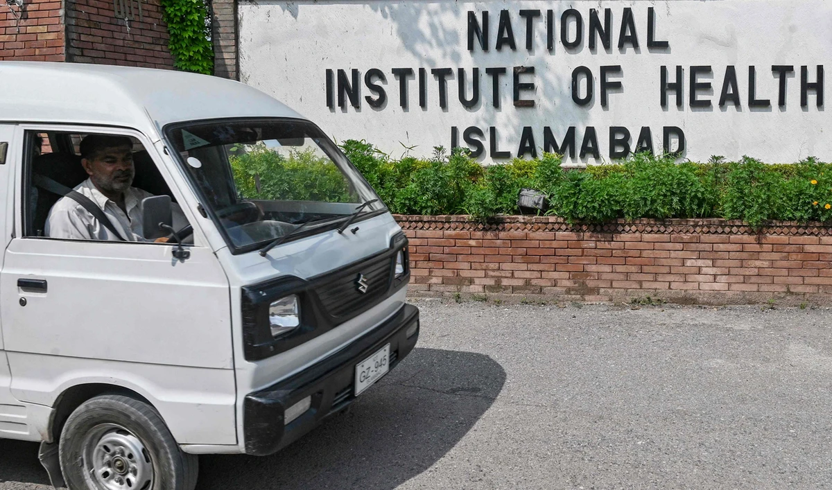 A man riding a vehicle moves past the building of National Institute of Health (NIH), a Pakistani research institute mainly responsible for biomedical and health related research, in Islamabad on August 16, 2024. (AFP/File)