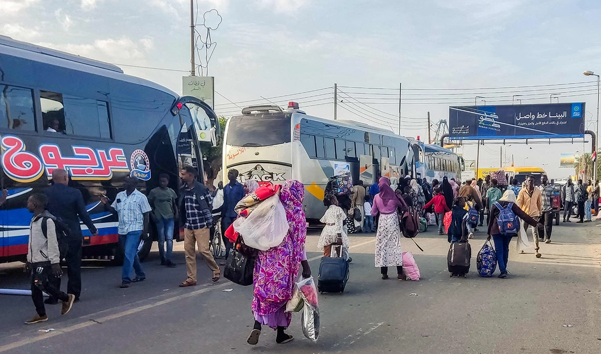 People displaced by conflict prepare to board a bus from Port Sudan in northeastern Sudan on January 7, 2025, to return home to the southern city of Singah in Sennar province, which was retaken by the Sudanese army forces from the Rapid Support Forces (RSF) in November 2024. (AFP)