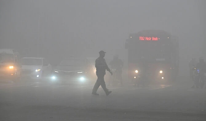 A man crosses a street engulfed in smog in Lahore on November 16, 2024. Pakistan’s most populated province of Punjab on on November 15 extended school closures in smog-hit major cities by a week, with thousands hospitalized as the country battles record air pollution. (AFP/File)