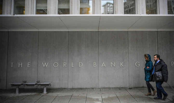 Two perosns walk by the building of the Washington-based global development lender, The World Bank Group, in Washington on January 17, 2019. (AFP/File)