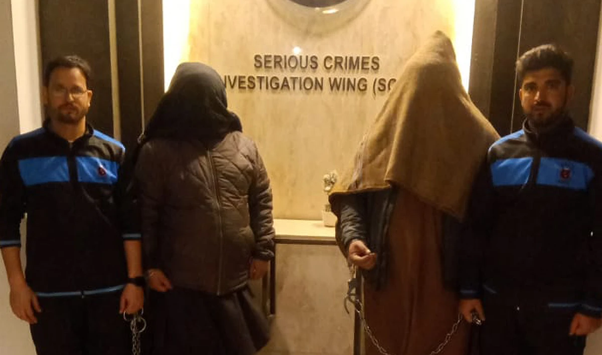 In this handout photograph, taken and released by the Quetta Police on January 29, 2025, Pakistani police officers present two men, detained for killing daughter over alleged blasphemy, at a police station in Quetta. (Handout/Quetta Police)