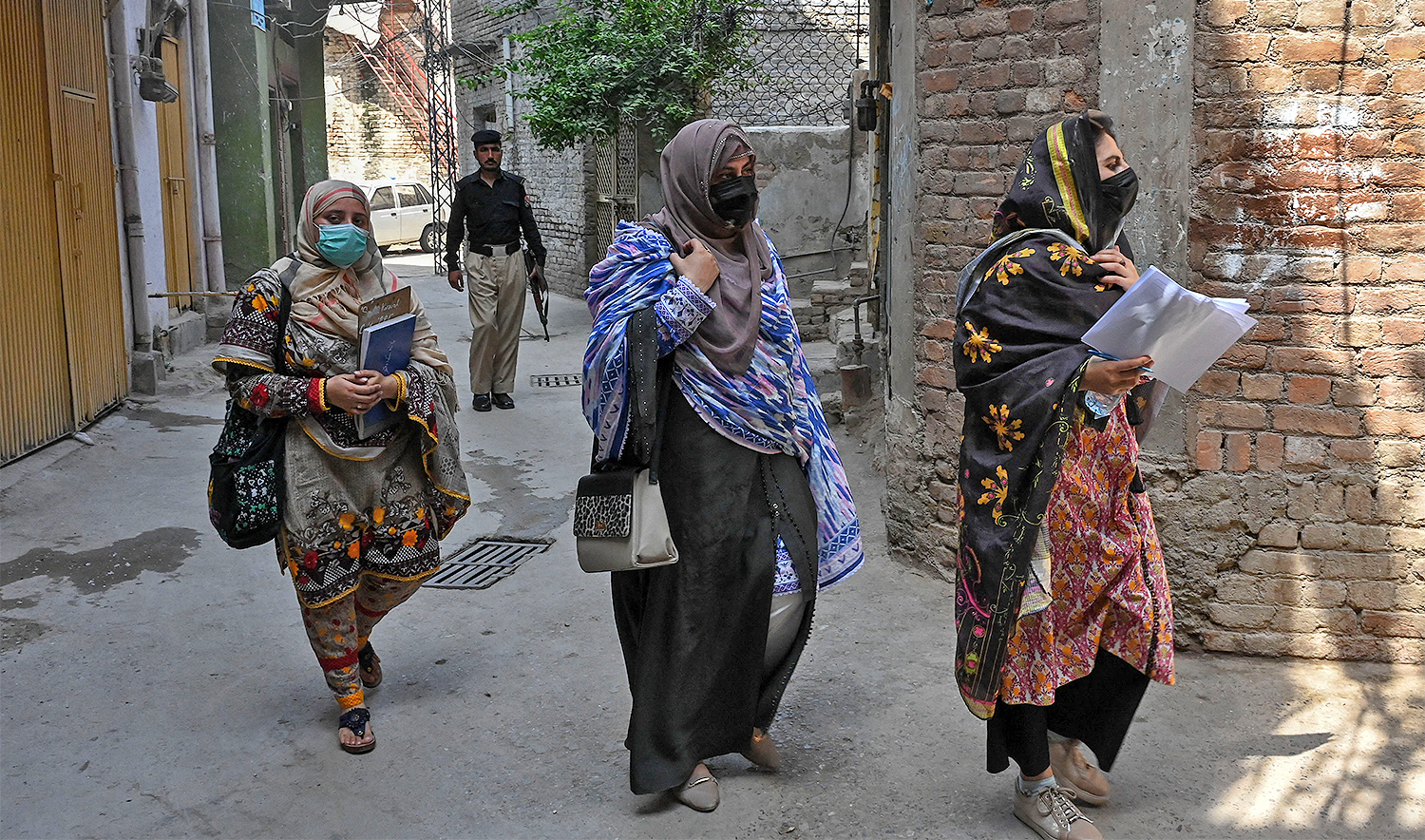 Health workers visit a residential area along with a security personnel during a polio vaccination campaign in Peshawar on May 22, 2023. (AFP/File)