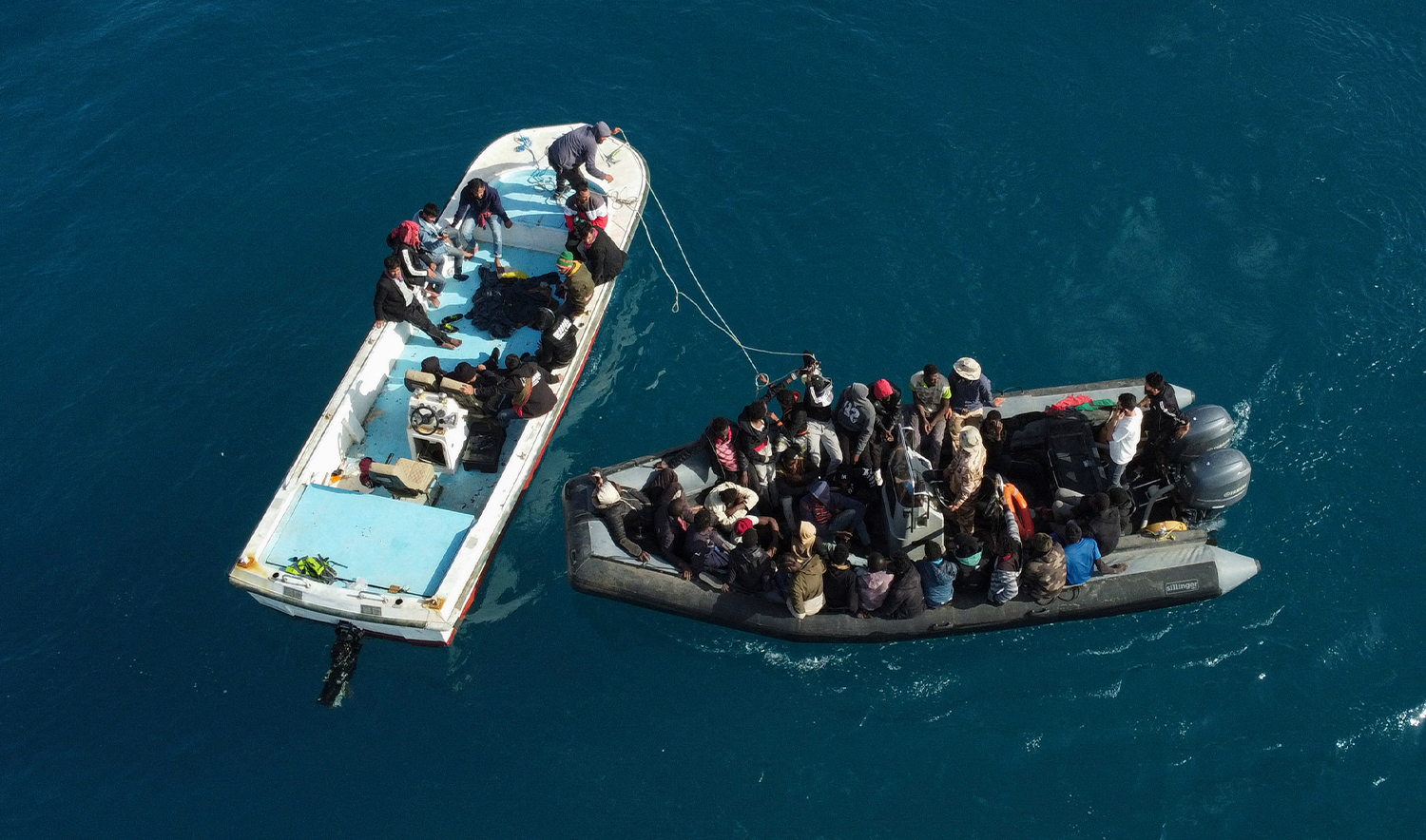 An aerial picture shows boats transporting migrants of different nationalities entering a port in the Garabulli area following their rescue at sea by the Libyan Coast Guard, on April 25, 2023. (AFP/File)
