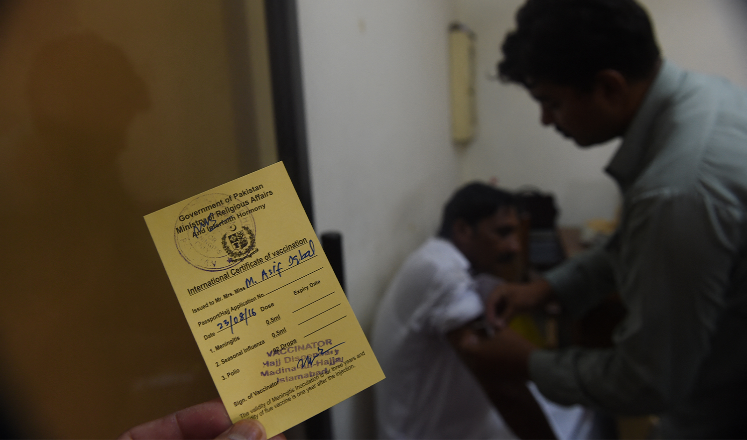 A Pakistani Hajj pilgrim is vaccinated by a paramedic at The Hajj Complex in Islamabad on August 23, 2016. (AFP/File)