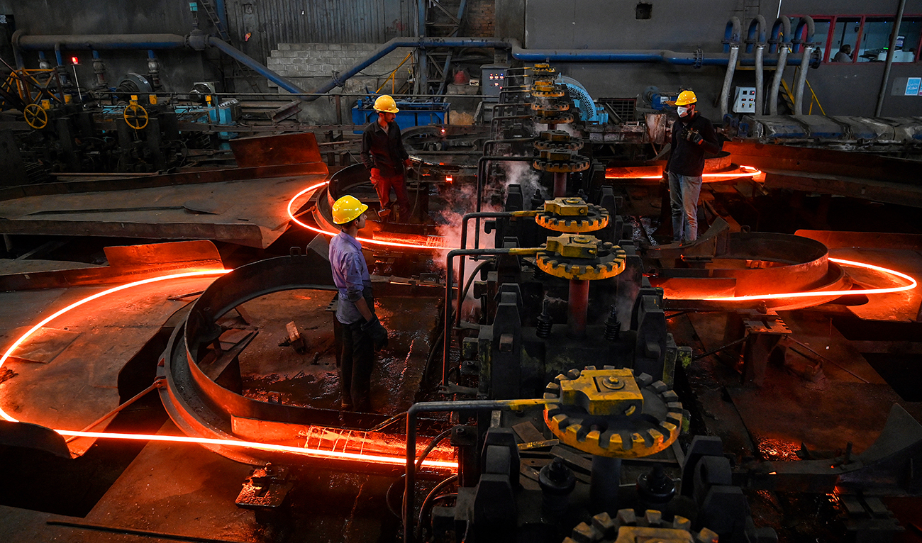 Labourers work on molten steel rods at a mill in Islamabad on April 30, 2024. (AFP/File)