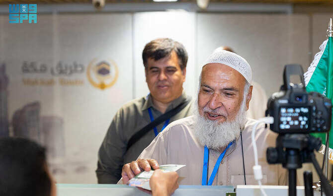 An official of Makkah Route handovers the passport of a pilgrim at immigration as he leaves for Saudi Arabia for the annual Hajj pilgrimage from Pakistan on May 20, 2024. (SPA/File)