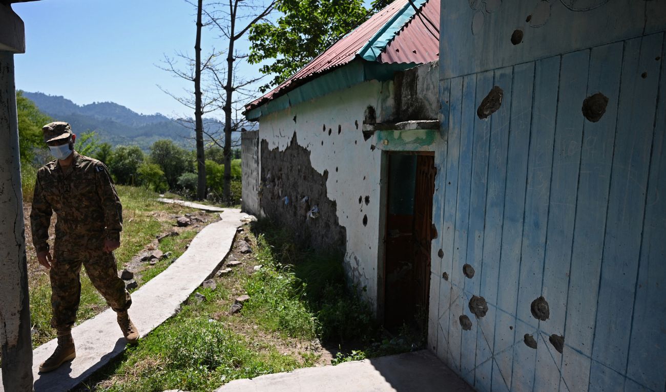 An army official walks past a damaged house following cross border shelling on the Line of Control, de facto border between India and Pakistan at Salohi village in Poonch district of Pakistan-administered Kashmir on April 26, 2021. (AFP/File)
