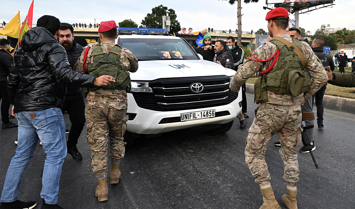 Lebanese army soldiers protect a convoy of the United Nations peacekeeping forces in Lebanon (UNIFIL), as Hezbollah supporters try to block the road that links to Beirut's international airport during a protest against Lebanon's decision to revoke permission for an Iranian carrier after Israel accused Iran of smuggling cash to Hezbollah, in Beirut, Lebanon, on Feb. 15, 2025. (AP)