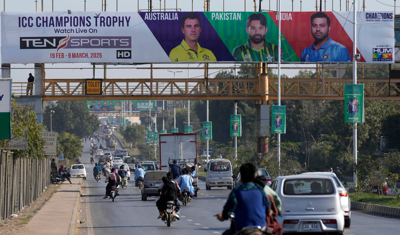 Cars and motorcyclists drive past a billboard depicting portraits of the various cricketers in preparation for ICC Champions Trophy 2025, installed on a pedestrian bridge on a road in Karachi, Pakistan, Sunday, February 16, 2025. (AP)
