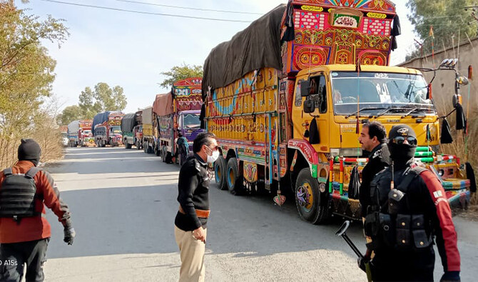 Security personnel stand beside aid supply trucks parked along a roadside in Hangu on January 22, 2025. (Hangu Police/File)