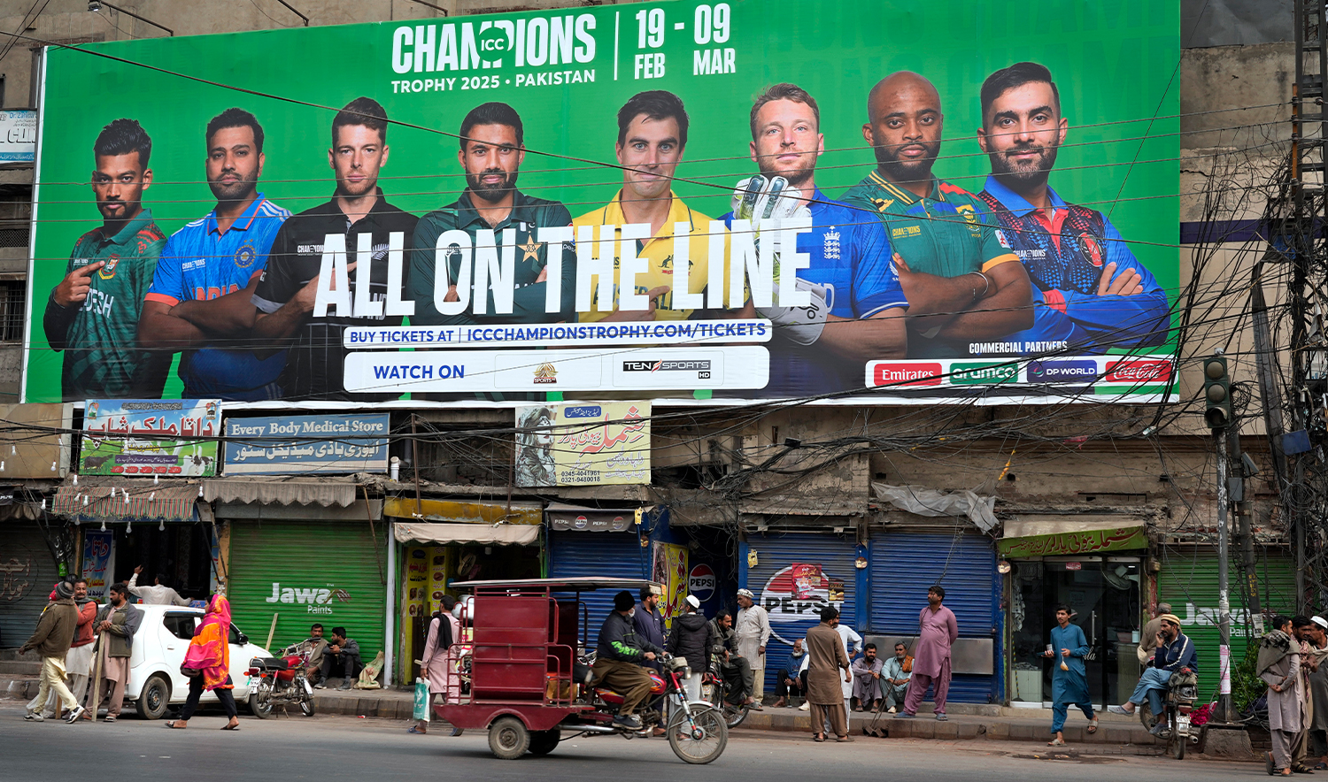 An auto-rickshaw drives past a billboard depicting portraits of the captains of participating cricket teams in ICC Champions Trophy 2025, installed at a roadside, in Lahore, Pakistan, on Feb. 16, 2025. (AP)