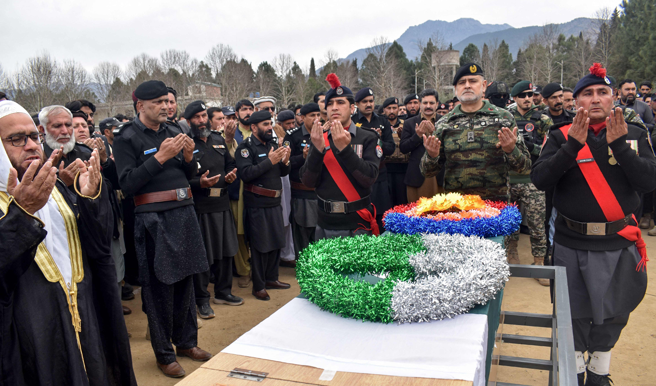 Security personnel offer prayers during the funeral ceremony of a slain police officer, killed on duty to escort a poliovirus vaccination team at Bajaur district in northwestern Khyber Pakhtunkhwa province on February 19, 2025. (AFP)