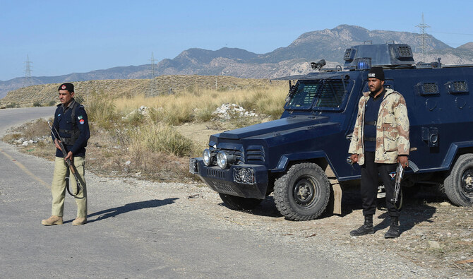 Policemen stand guard along a road in a village in Karak district in Pakistan on December 31, 2020. (AFP/File)