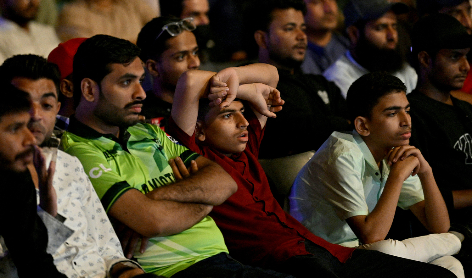 Cricket fans react as they watch a live broadcast of the ICC Champions Trophy one-day international (ODI) cricket match between India and Pakistan in Dubai, on a big in Karachi on February 23, 2025. (AFP)