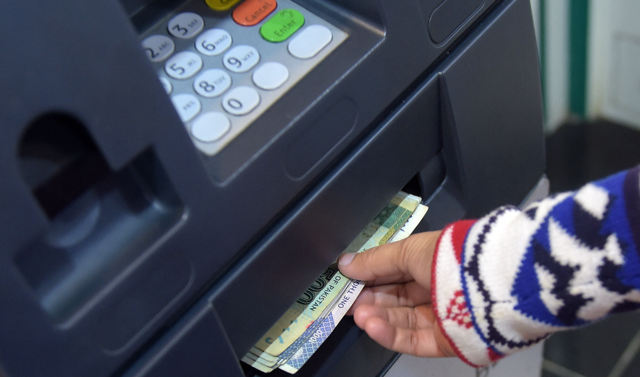 This photograph taken on March 6, 2015 shows a Pakistani resident withdrawing currency from an ATM in Islamabad. (AFP/File)