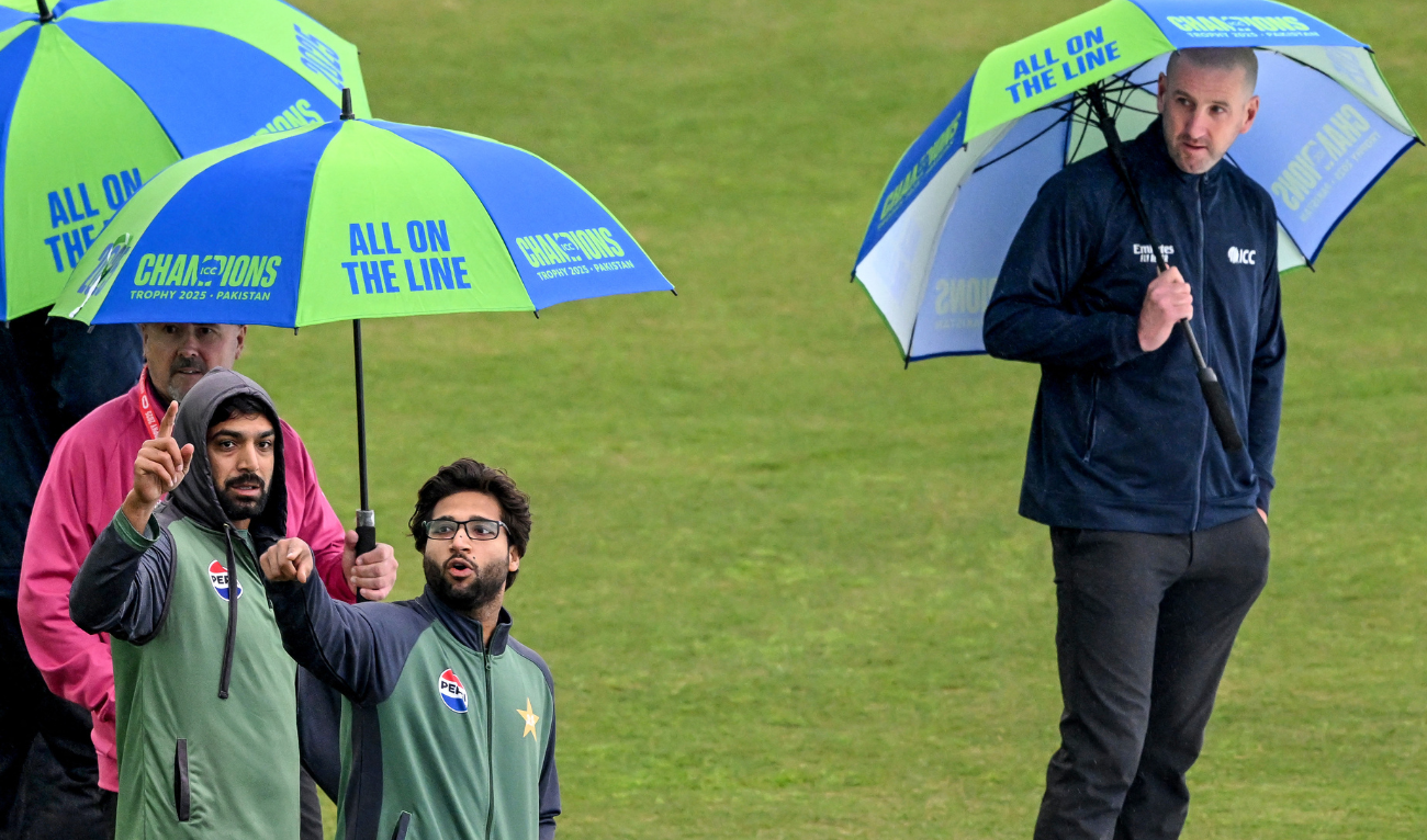 Pakistan's Imam-ul-Haq (2R) speaks with teammate Haris Rauf (2L) as field umpire Michael Gough (R) inspects the outfield after rain delayed the start of the ICC Champions Trophy one-day international (ODI) cricket match between Pakistan and Bangladesh at the Rawalpindi Cricket Stadium in Rawalpindi on February 27, 2025. (AFP)