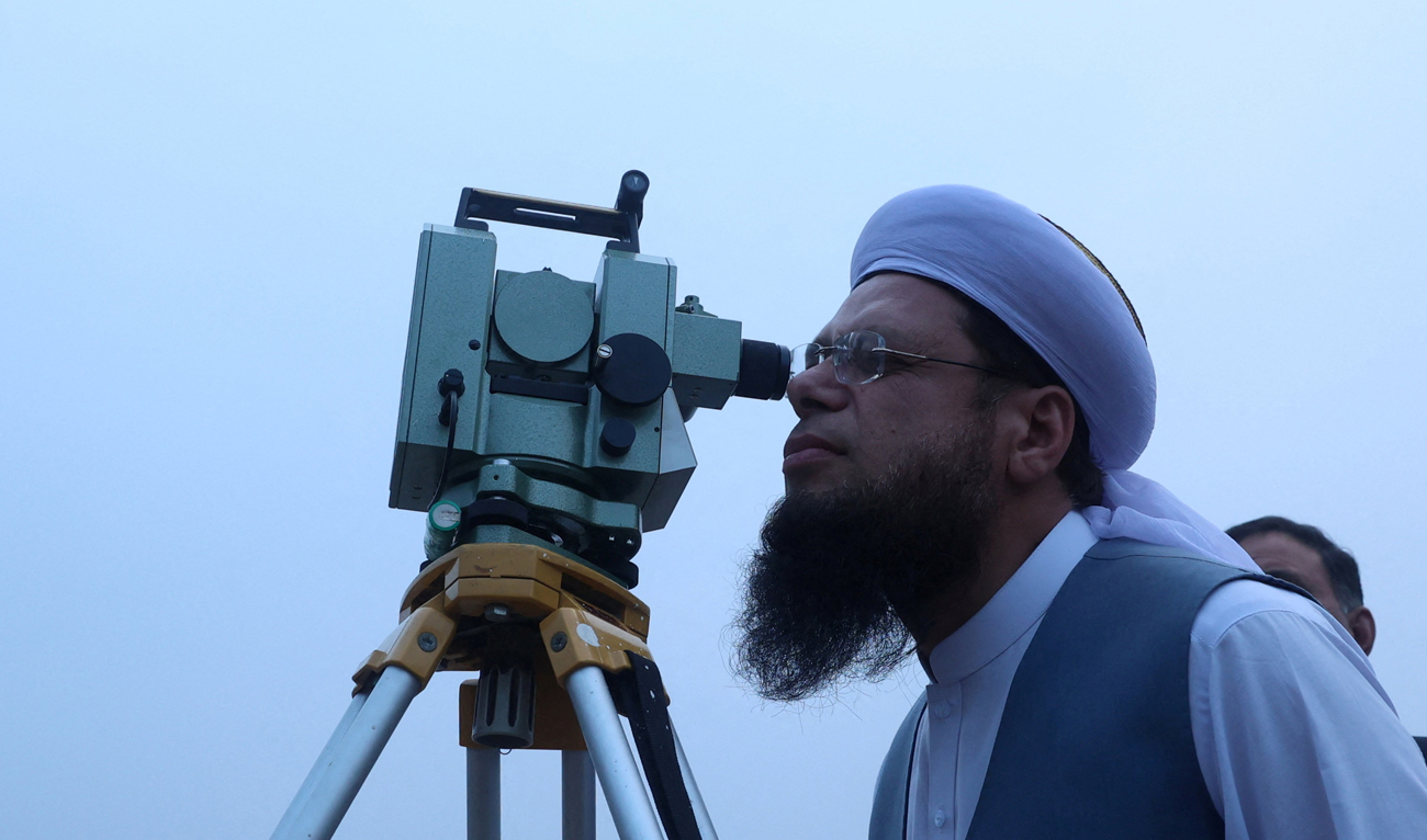 A member of Central Ruet-e-Hilal Committee, Pakistan’s moon sighting committee, uses a theodolite to look for the new moon that will mark the start of the holy fasting month of Ramadan, in Peshawar on February 28, 2025. (REUTERS)