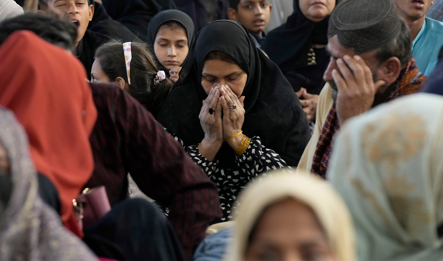 A woman prays as she with others wait for pre-dawn meal or 'Sehri' to start their fasting during the Muslim's holy fasting month of Ramadan, at a free meal distribution center run by a charity group, in Karachi, Pakistan, on March 2, 2025. (AP)