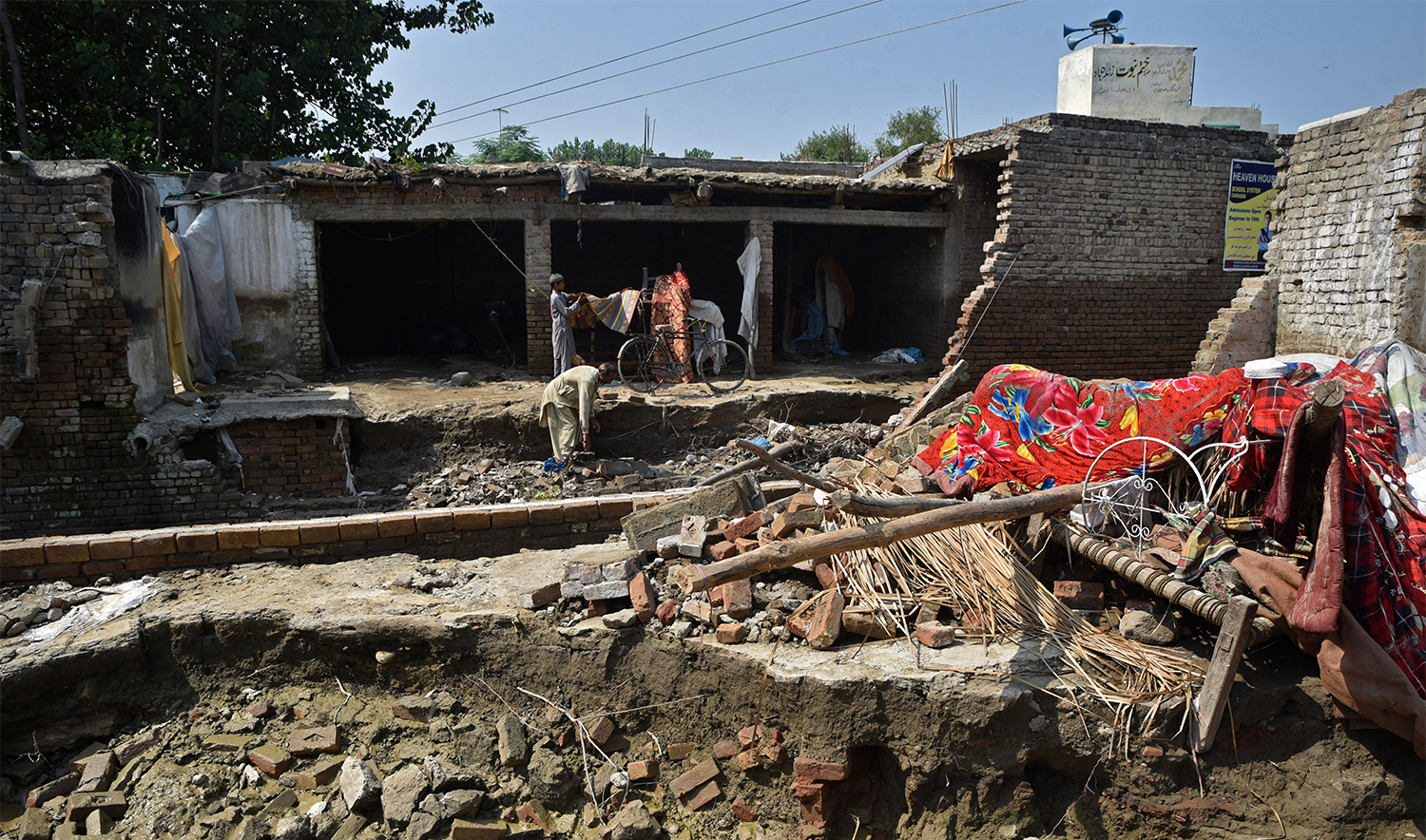Flood-affected residents collect their belongings from their collapsed house by flood waters following heavy monsoon rains in Charsadda district of Khyber Pakhtunkhwa on August 31, 2022. (AFP/File)