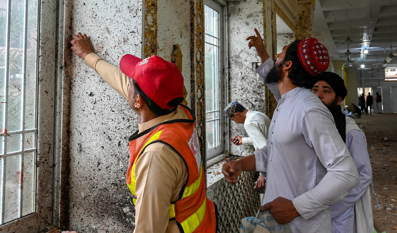 A rescuer collects remnants after a suicide blast amid friday prayers at Dar-ul-Uloom Haqqania school in Akora Khattak, east of Peshawar, Pakistan, on February 28, 2025. (AFP/File)