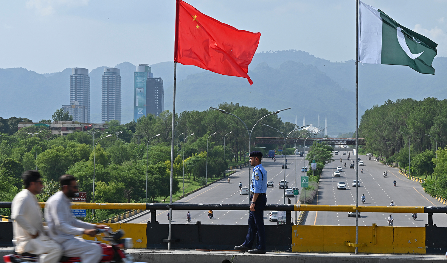 A policeman stands guard under the national flags of China and Pakistan along a road ahead of the visit of Chinese Vice Premier He Lifeng, in Islamabad on July 30, 2023. (AFP/File)