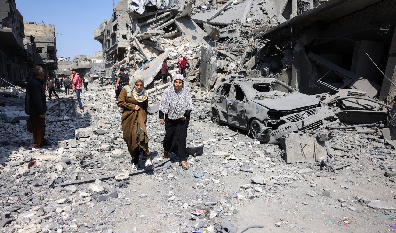 People walk amid the rubble of a building destroyed in an overnight Israeli strike in Jabalia, in the northern Gaza Strip on March 18, 2025. (AFP)