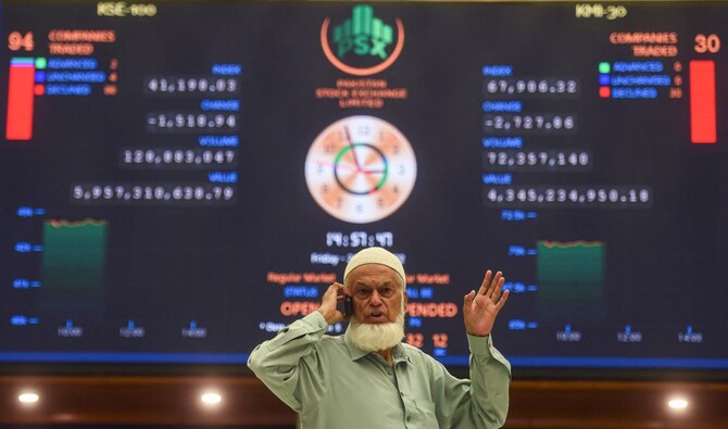 A stockbroker speaks on a phone while monitoring the share prices during a trading session at the Pakistan Stock Exchange (PSX) in Karachi on June 24, 2022. (AFP/File)