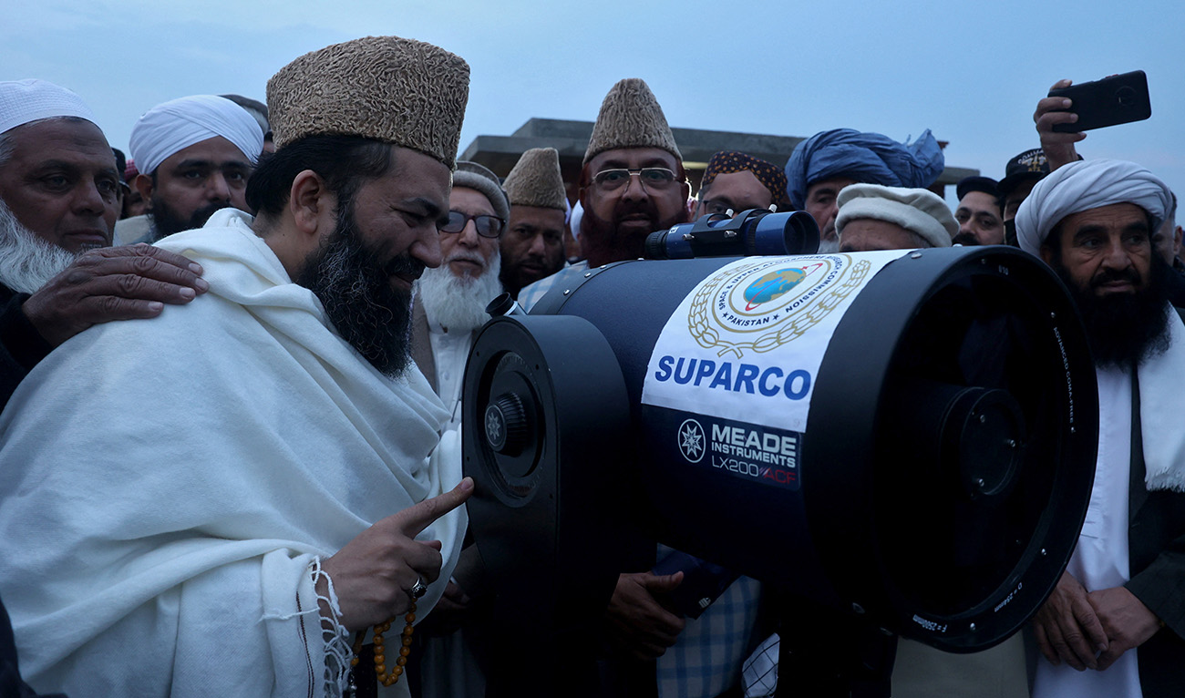 Maulana Abdul Khabeer Azad, Chairman of Central Ruet-e-Hilal Committee, Pakistan's moon sighting committee, along with others members use a telescope to look for the new ahead of ramadan in Peshawar, Pakistan, February 28, 2025. (Reuters/File)