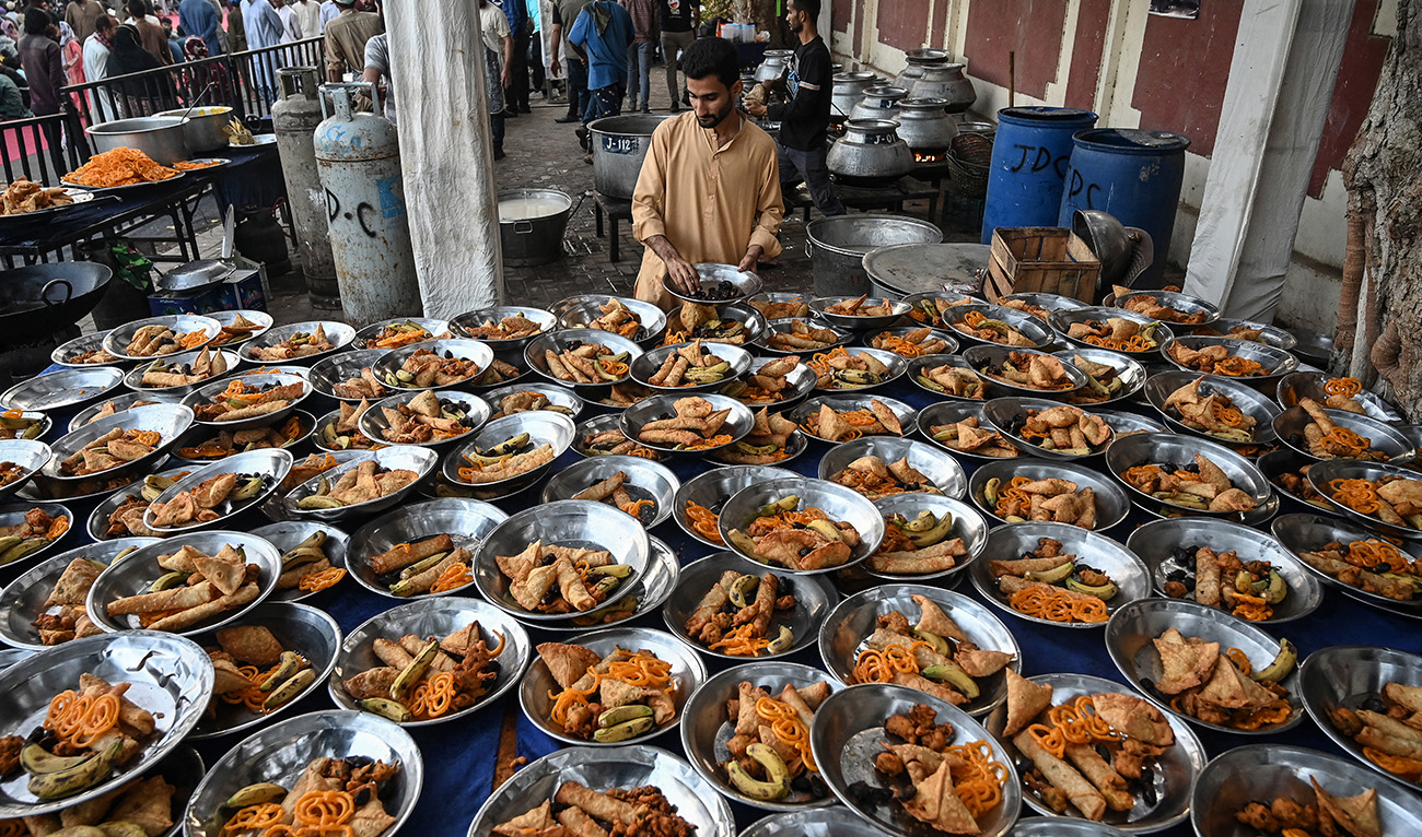A volunteer arranges iftar meals prepared for Muslims waiting to break their fast during the Islamic holy fasting month of Ramadan in Karachi on March 5, 2025. (AFP)