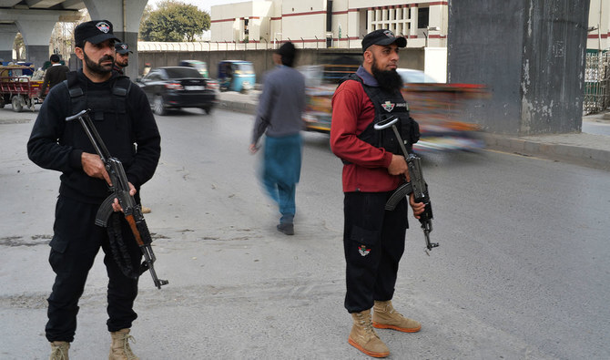 In this file photo, taken on February 1, 2023, policemen stand guard along a street in Peshawar, days after a suicide bombing inside a police headquarters last year. (AFP/File)
