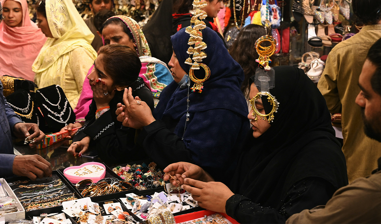 People shop at a market ahead of Eid al-Fitr that marks the end of the Muslim holy fasting month of Ramadan, in Lahore, Pakistan, on March 30, 2025. (AFP)
