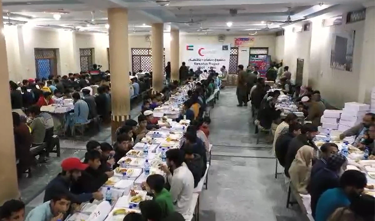 The screengrab from a video shared by the UAE consulate in Karachi on March 2, 2025, shows people eating iftar boxes donated by Emirates Red Crescent in Pakistan. (UAE consulate in Karachi/Screengrab)