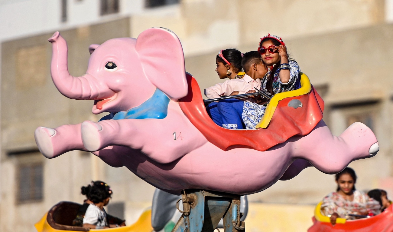 People enjoy rides at a carnival during celebrations a day after Eid al-Fitr, that marks the end of the Islamic holy fasting month of Ramadan, in Karachi on April 1, 2025 (AFP)