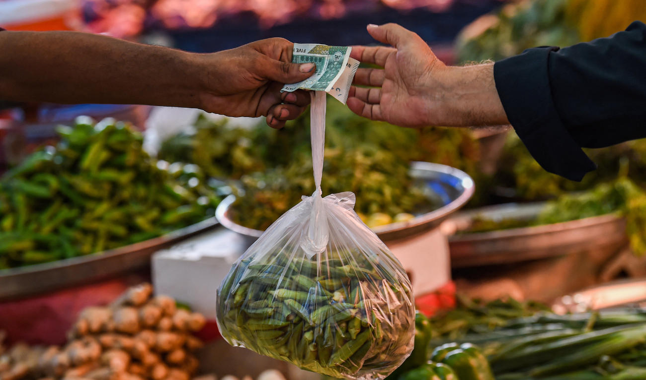 A customer buys vegetables from a stall at a market in Karachi on July 3, 2023. (AFP/ File)