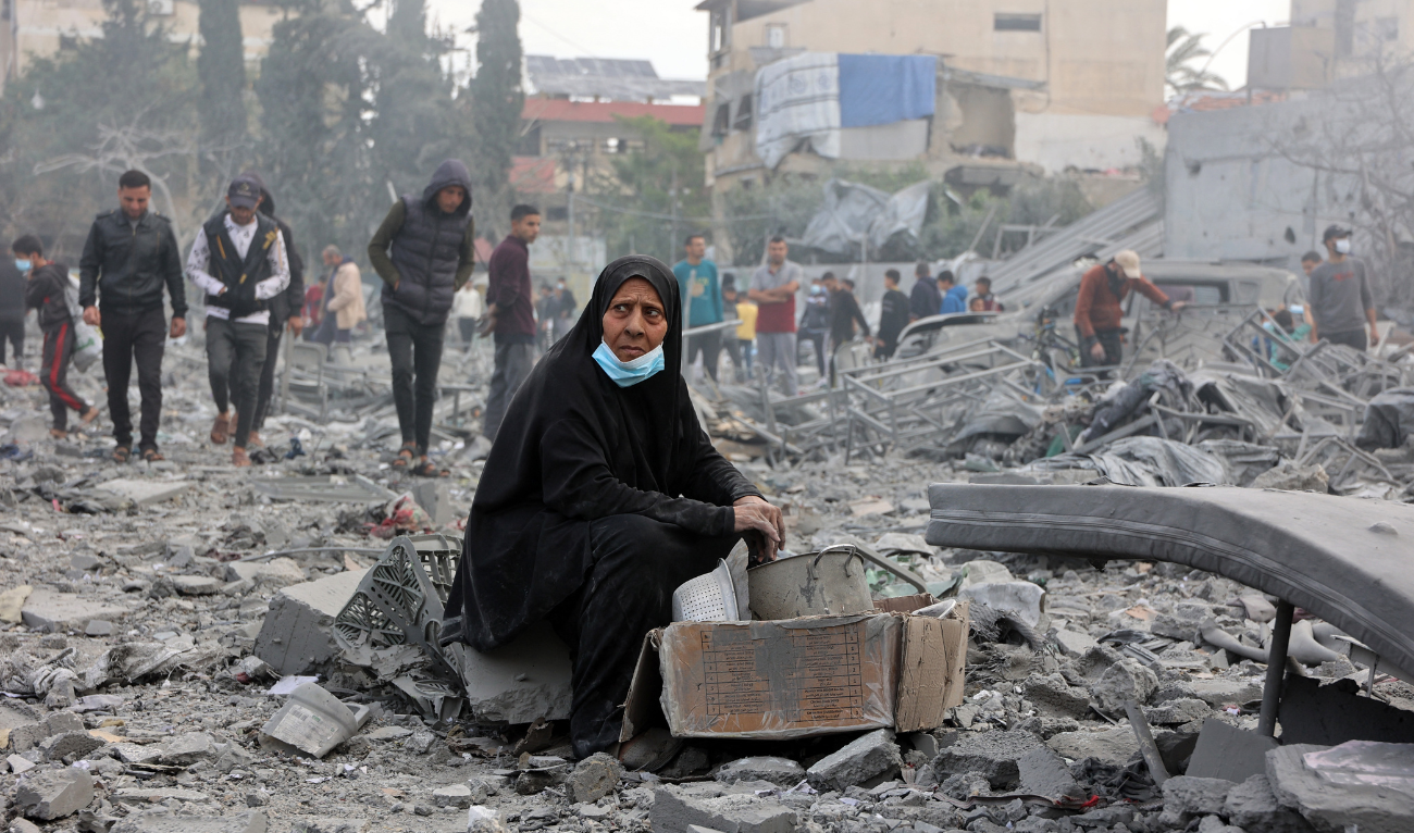 A Palestinian woman sits amid the devastation in the yard of a school, a day after it was hit by an Israeli strike, in the al-Tuffah neighbourhood in Gaza City on April 4, 2025. (AFP)