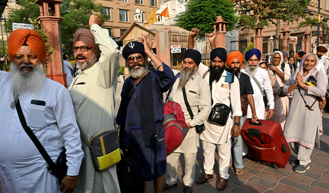 Sikh pilgrims gesture as they queue up to board a bus leaving for Pakistan during 'Baisakhi' a spring harvest festival, in Amritsar, India, on April 10, 2025. (AFP)
