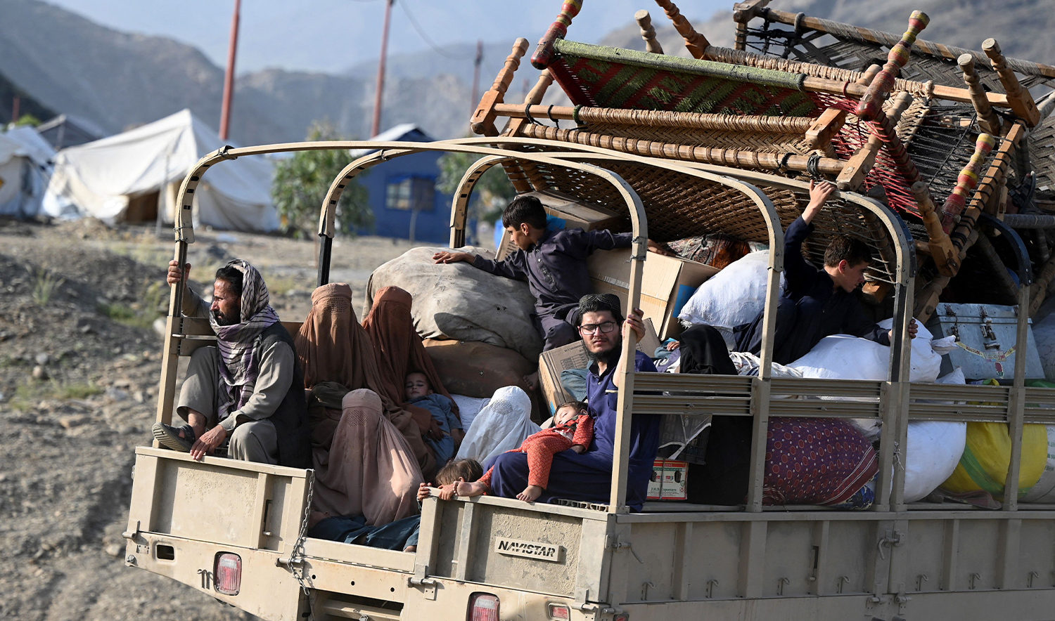 Afghan refugees with their belongings sit in a truck as they arrive from Pakistan at a makeshift camp near the Afghanistan-Pakistan Torkham border in Nangarhar province on April 20, 2025. (AFP)