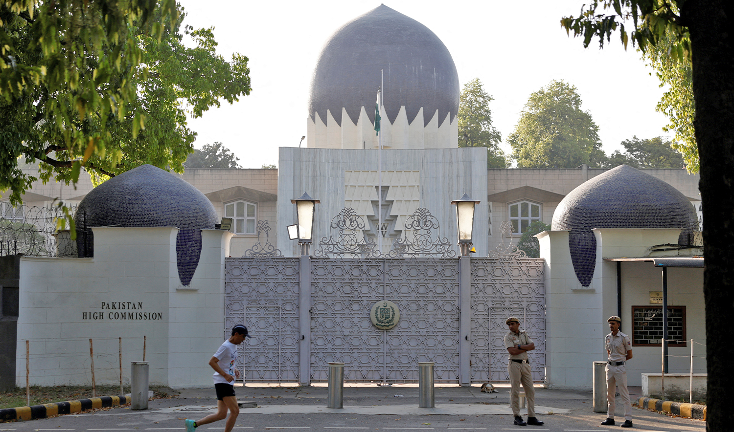 A man jogs past policemen standing outside the gate of Pakistan High Commission in New Delhi, India, on April 24, 2025. (REUTERS)
