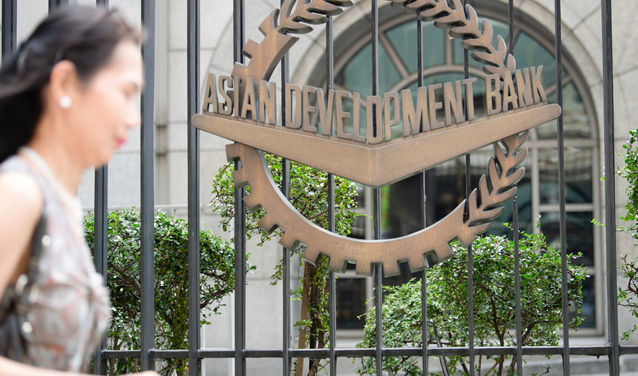 A woman walks past the logo of the Asian Development Bank (ADB) outside the bank's headquarters in Manila on April 15, 2025. (AFP/ file)