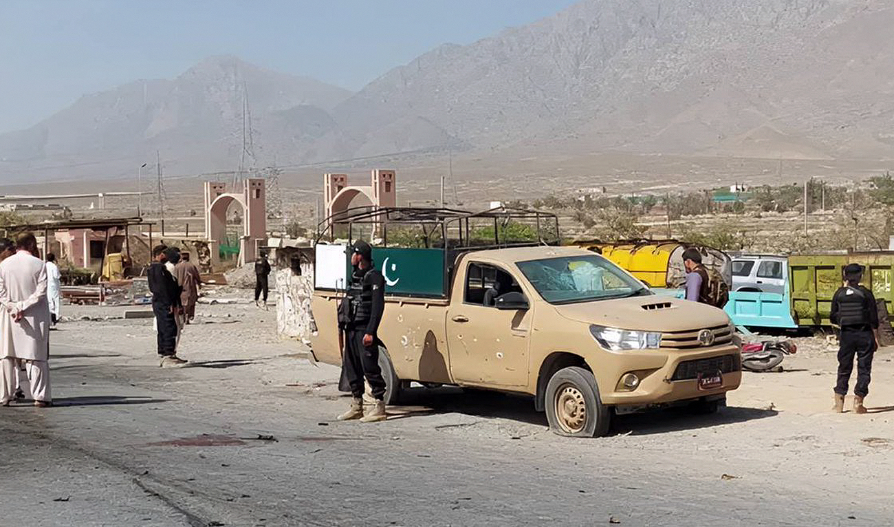 This undated file photograph shows security personnel stand guard next to a targeted vehicle in Mianghundi, southwest of Quetta, Pakistan. (Photo courtesy: X/@planetreporter1)