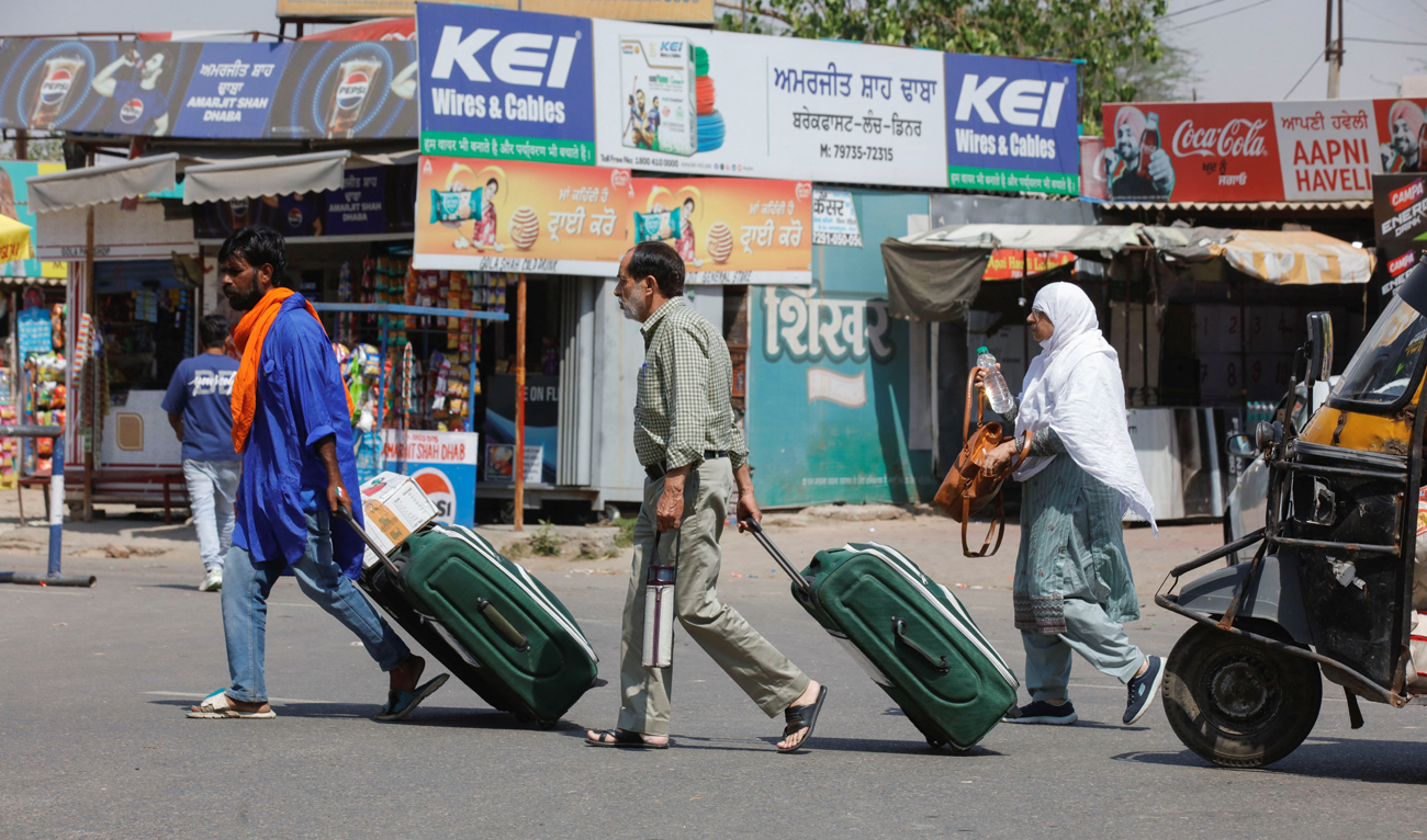 People carry baggage as they travel toward the Attari-Wagah border crossing on the India-Pakistan border, near Amritsar, India on April 25, 2025. (REUTERS)