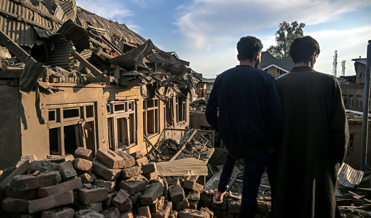 People gather near a damaged house related to the family of Ahsan Ul Haq Sheikh, who is suspected of involvement in the Pahalgam tourist attack, in Murran village of Pulwama, south of Srinagar, on April 26, 2025. (AFP)