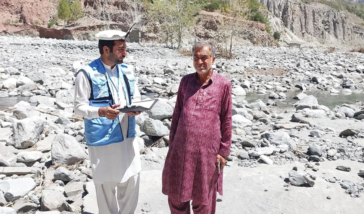 The undated file photo shows an OCHA staff member speaking with a 2024 flash flood victimvin Pakistan’s Khyber Pakhtunkhwa Province. Umer Dil. (Photo courtesy: OCHA/ website)