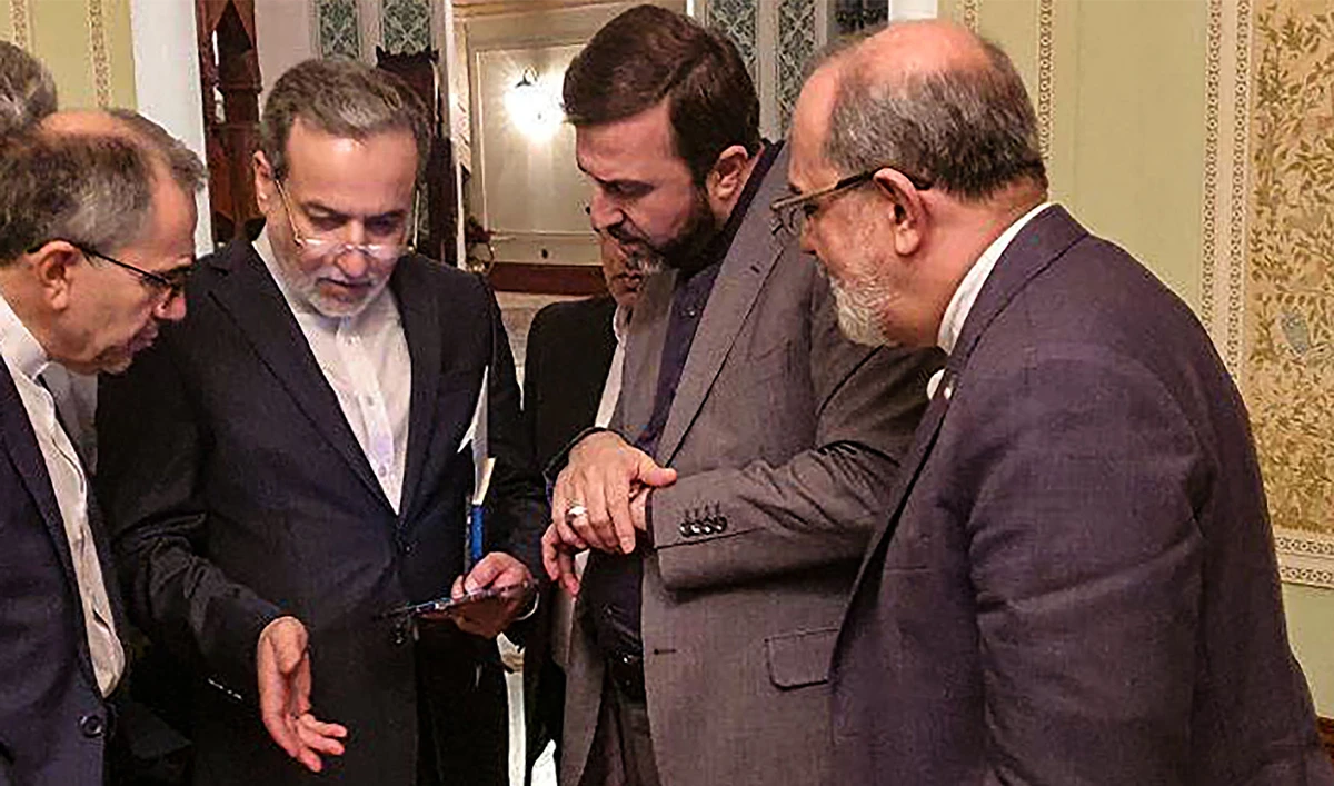 This handout picture provided by Khabar Online on April 12, 2025, shows Iran's Foreign Minister Abbas Araghchi (second left) speaking with members of the Iranian delegation after a meeting in Muscat, Oman. (AFP/KhabarOnline)